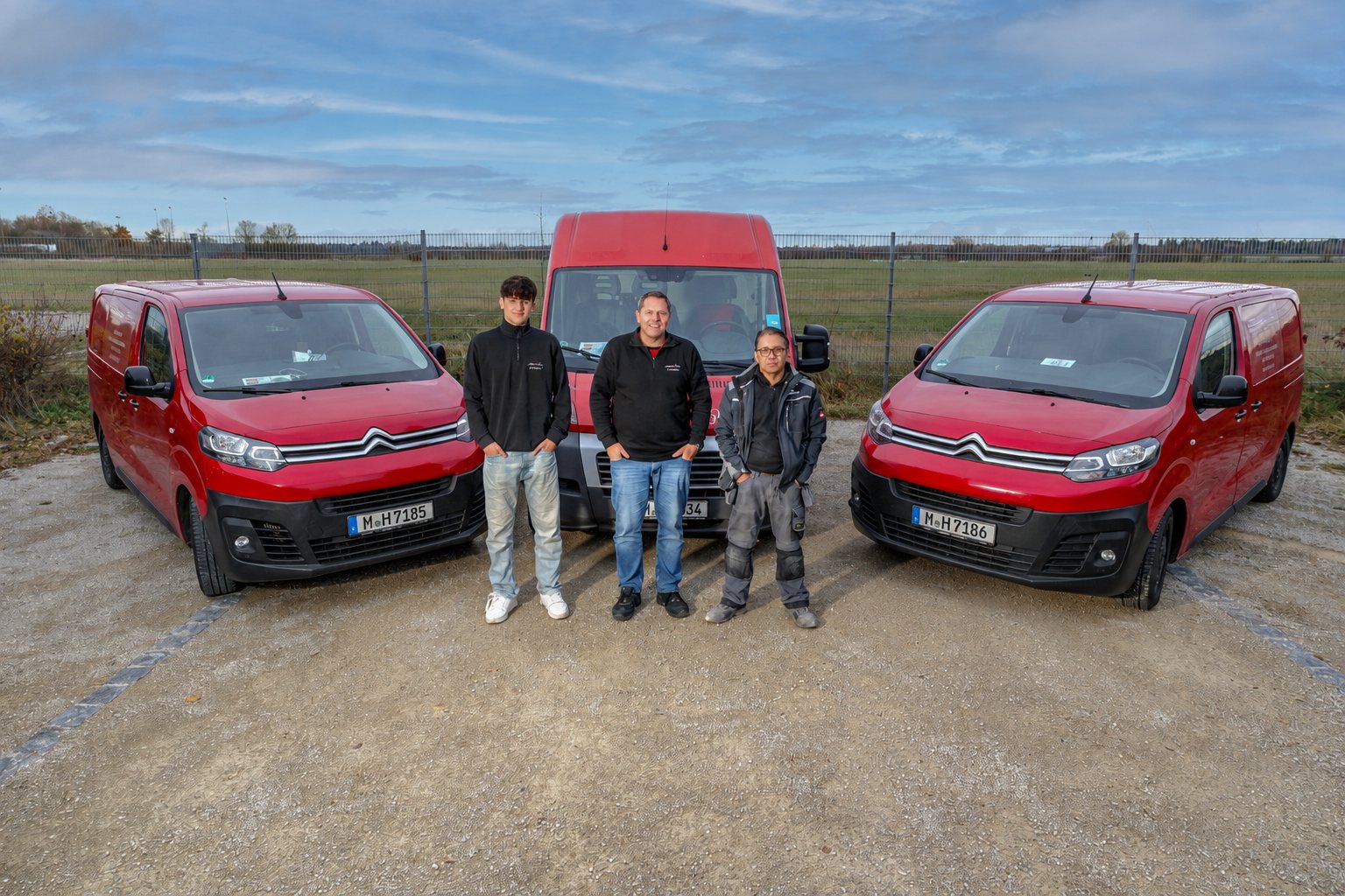 Das Team der elho-tec GmbH vor den roten Servicefahrzeugen